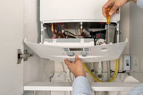 Heating technician repairing a residential boiler in Lynwood