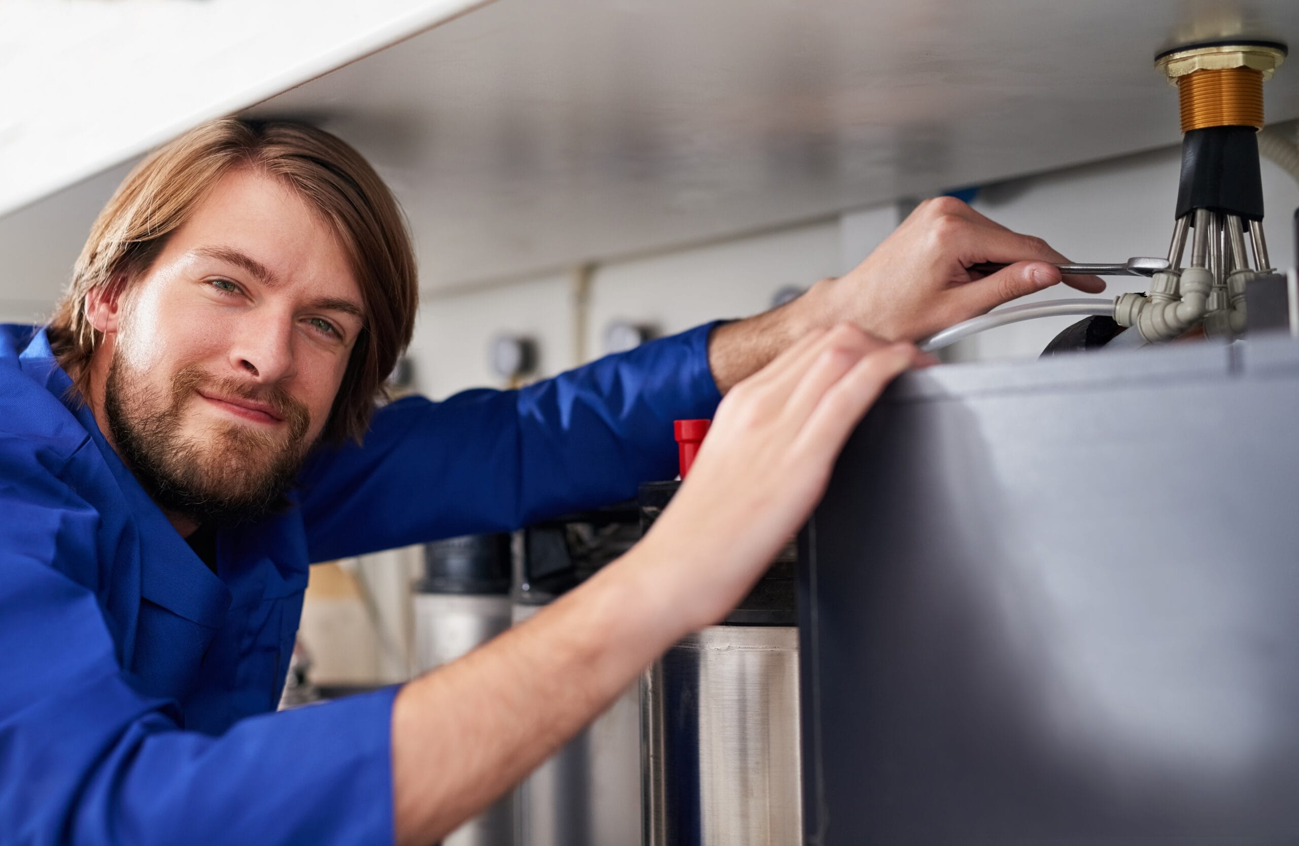 Technician servicing a residential water heater tank in Lynwood
